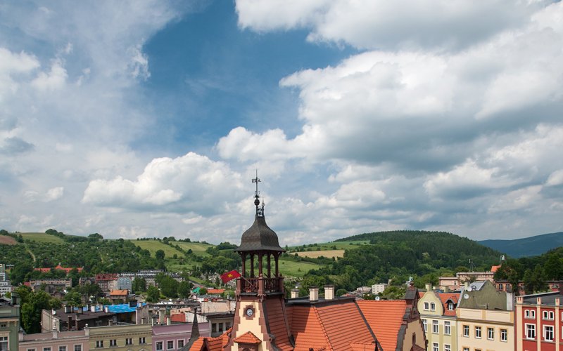 Kościół z wysoką wieżą pośród zielonych wzgórz